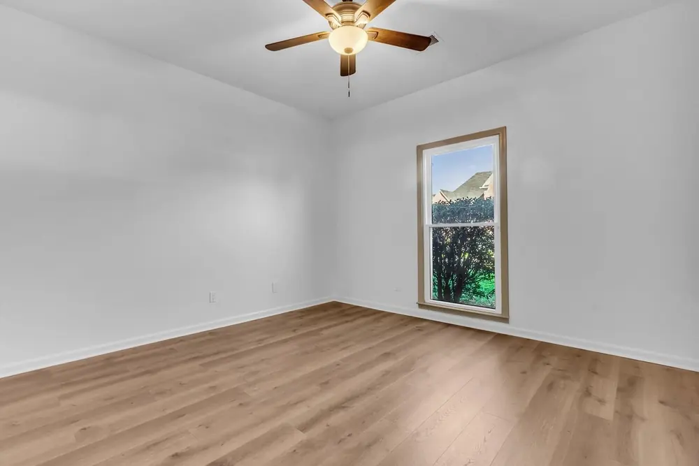 An empty bedroom, then virtually staged with a bed, nightstands and a bench.