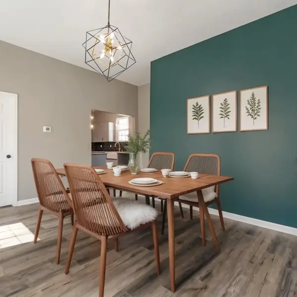 Une salle à manger meublée contre un mur vert.