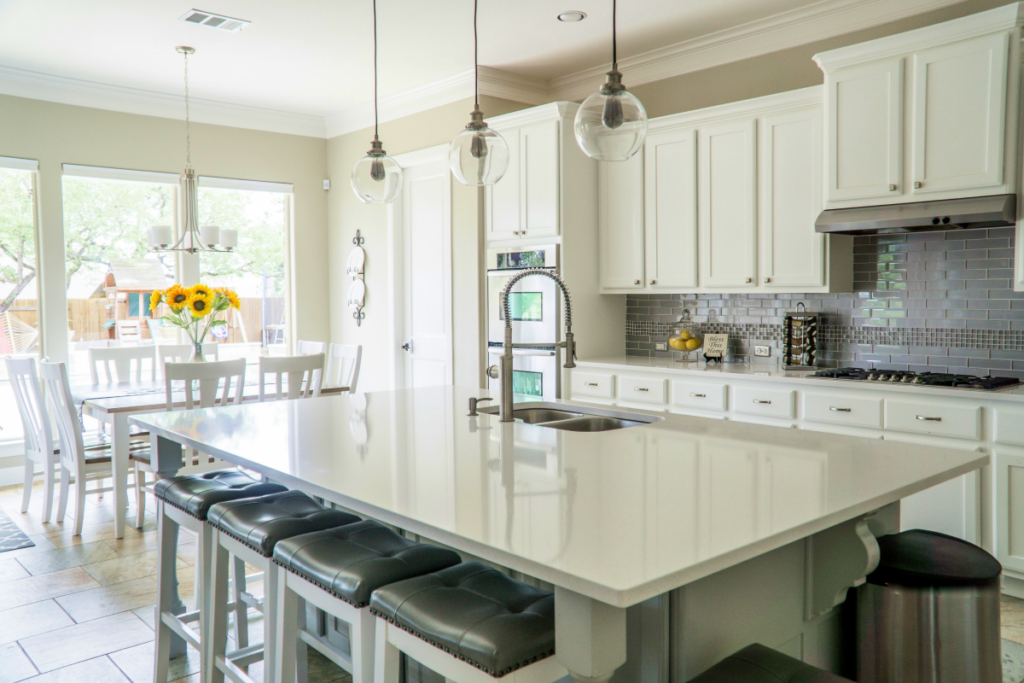 Bright kitchen interior with cleared countertops and minimal decor, showing how to keep surfaces clean without making rooms feel empty in real estate listing photos.